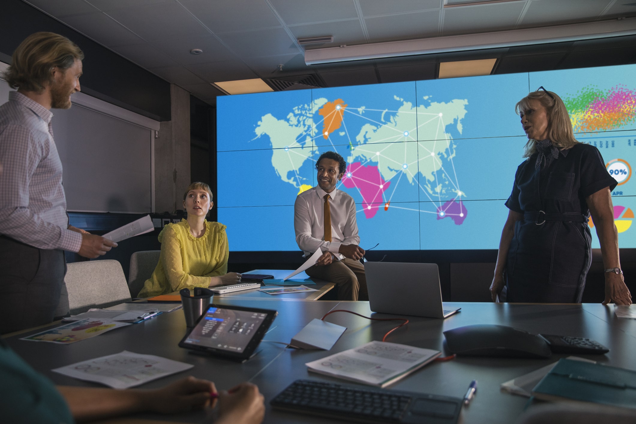 A global sustainability team meeting in a conference room in front of a world map.