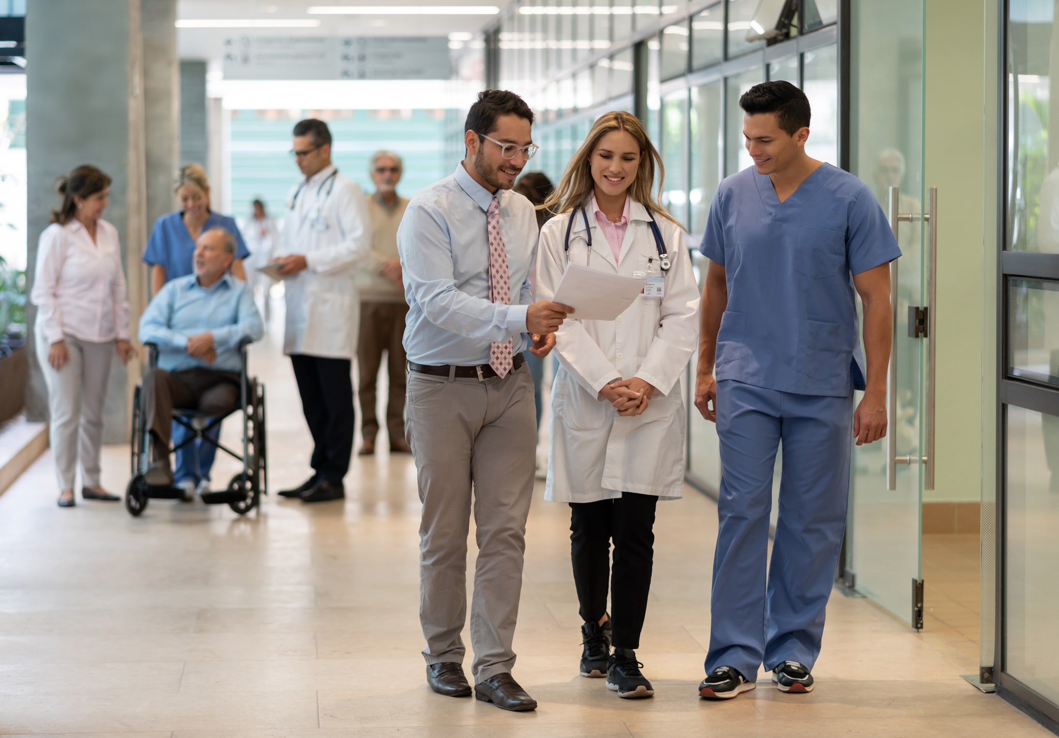 Hospital manager showing a document to doctor and nurse all smiling ONLINE master’s in HEALTHCARE ADMINISTRATION