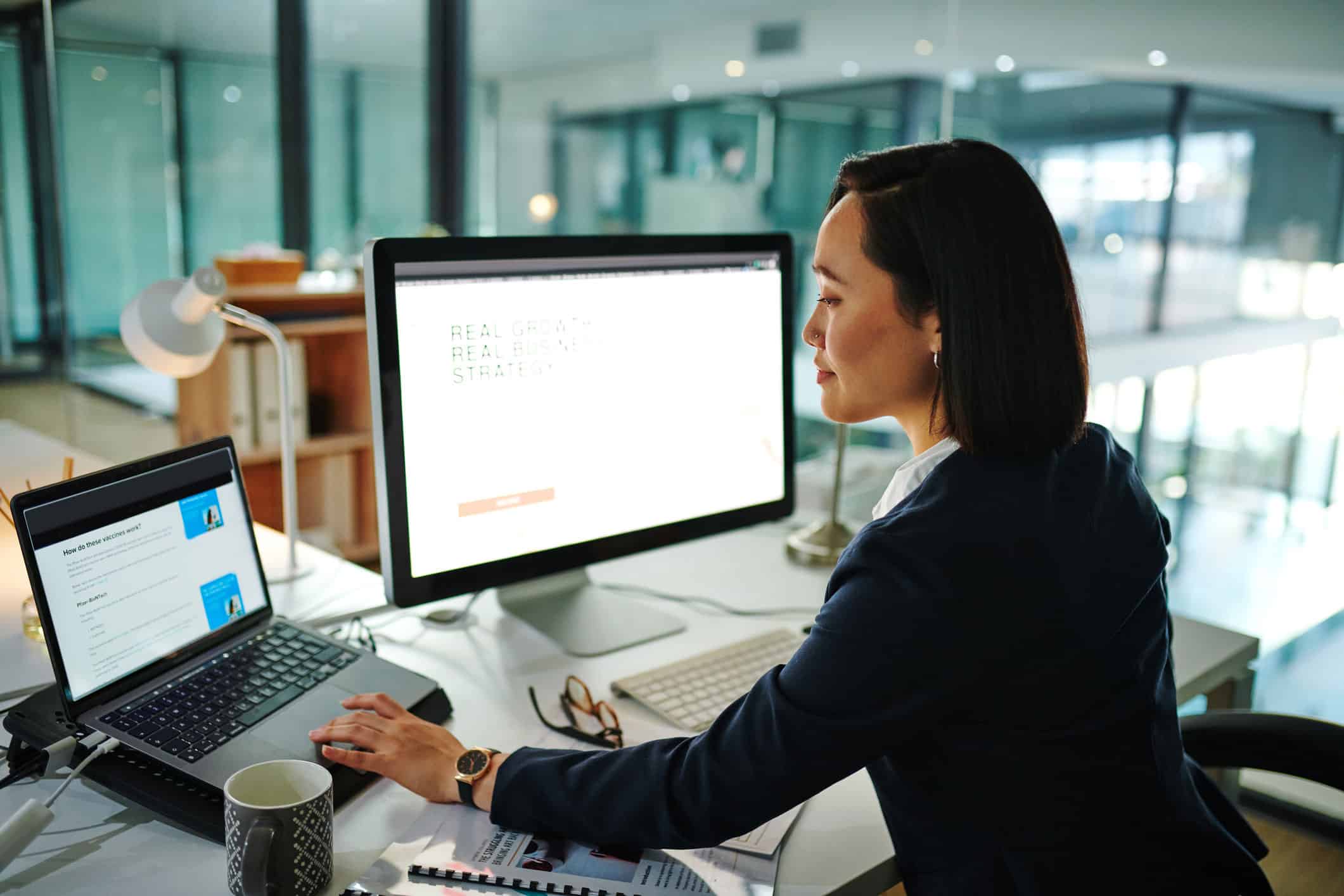 GettyImages-1368572465 An organizational development consultant works on a laptop with a desktop in an office.