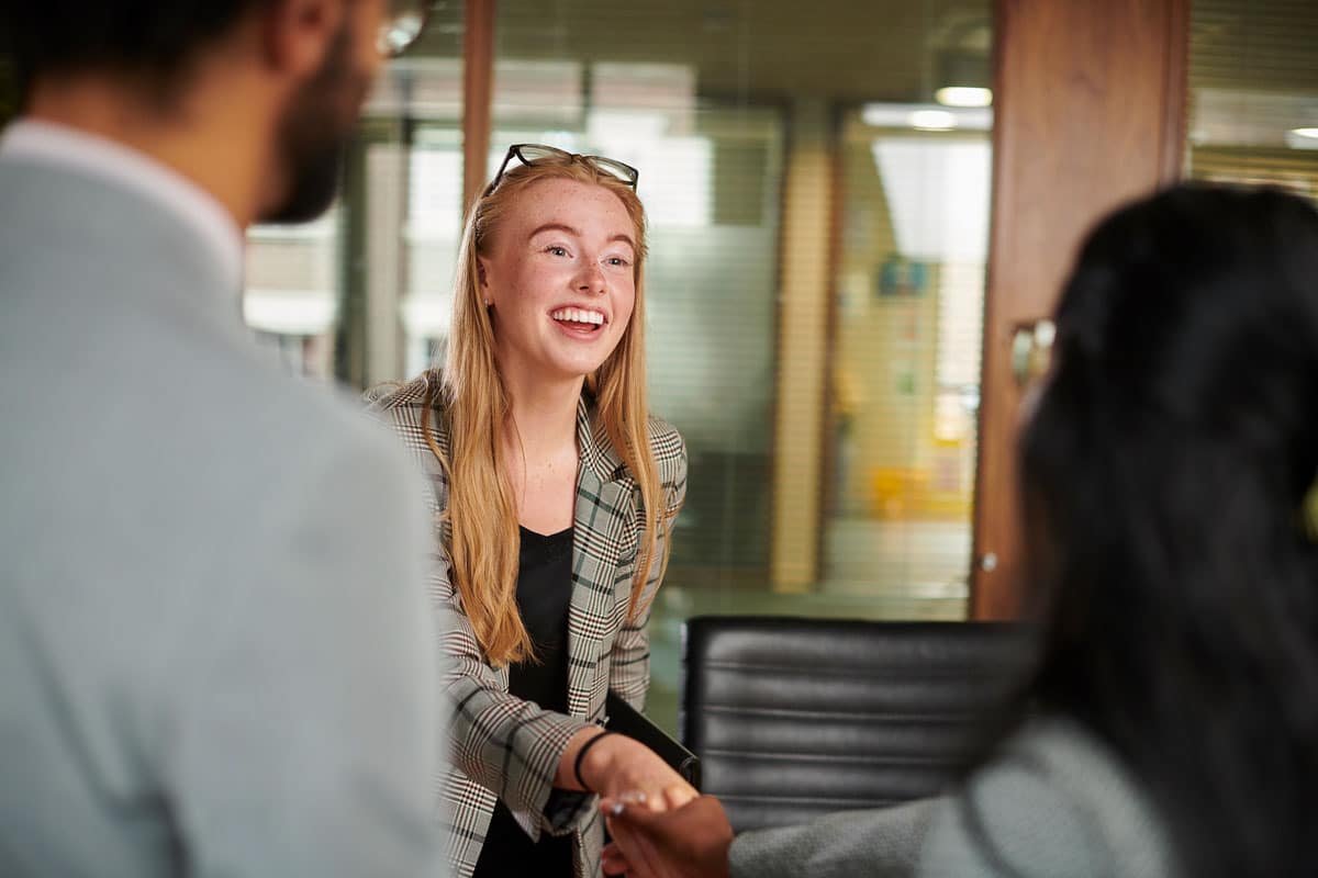 A candidate shaking hands with a panel member at an interview.