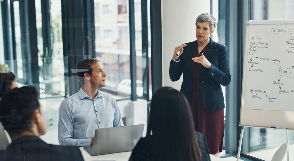 A training and development specialist presenting to a team in a conference room.