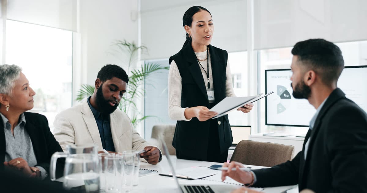 GettyImages-2057489585 A manager leads a team meeting around a conference table.