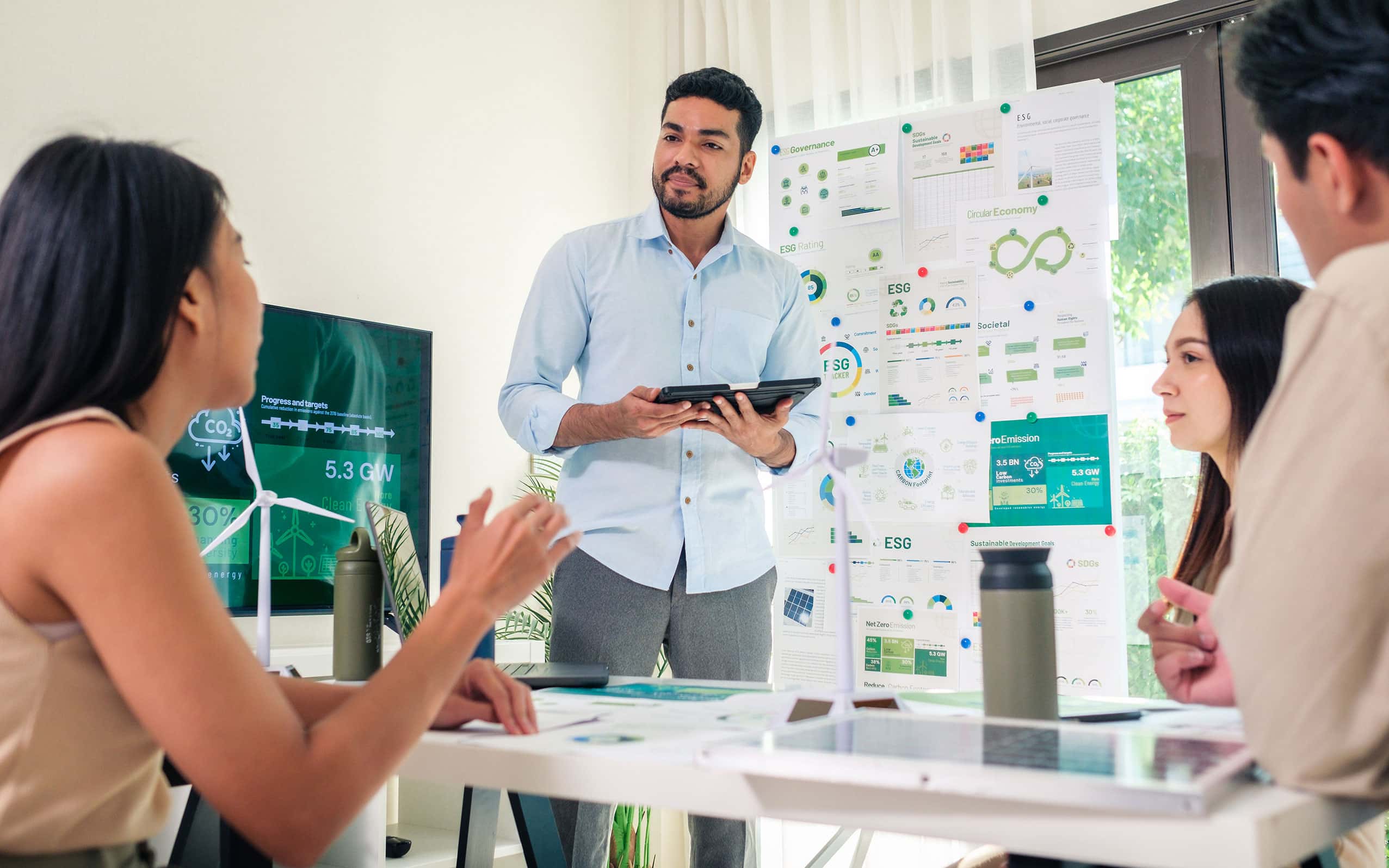 A sustainability director leads a brainstorming session with a small team.