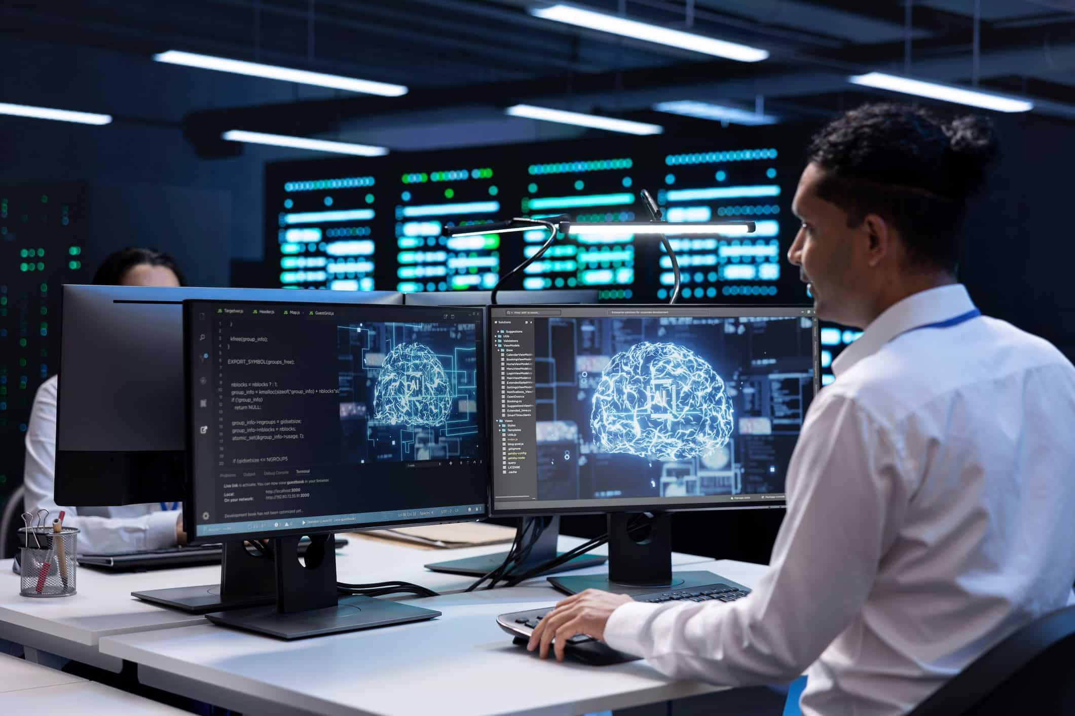 A network systems administrator world on a computer in a server room.