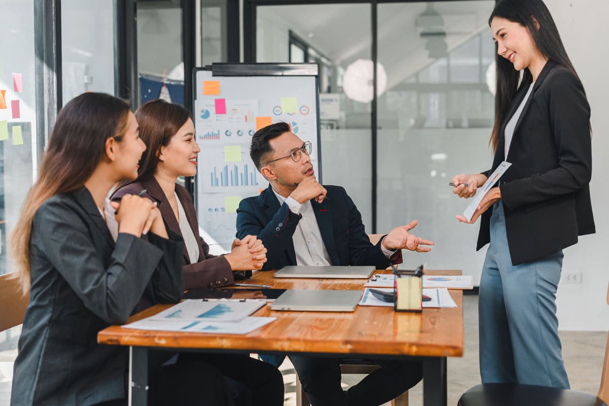 A project manager meets with her team in a conference room.