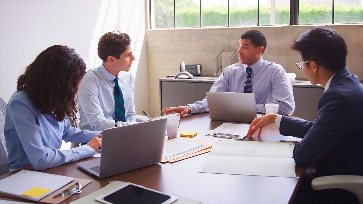 A meeting of public administrators around a conference table.