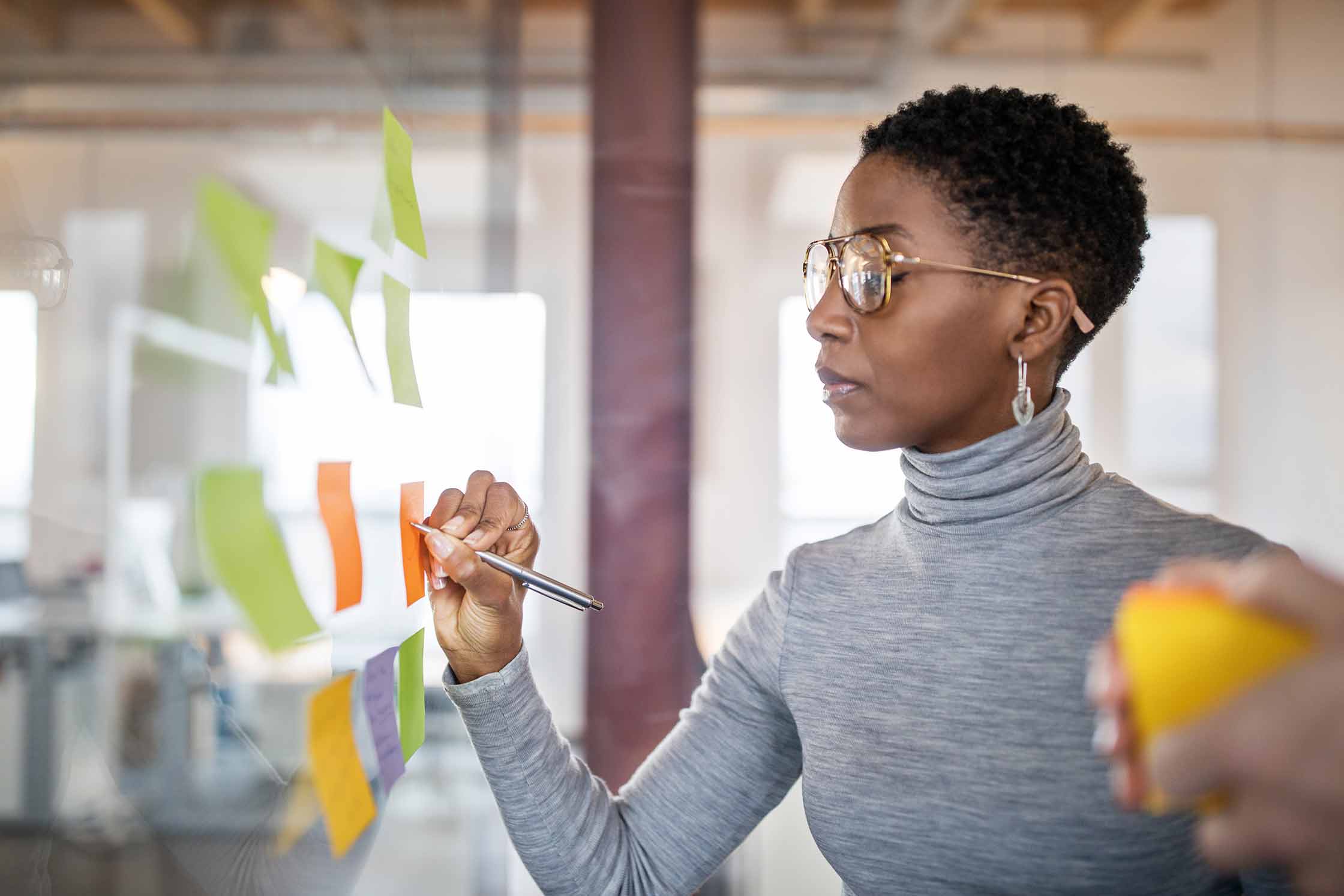 Master’s in organizational leadership: Professional Studies Degree a woman observing a wall of sticky notes